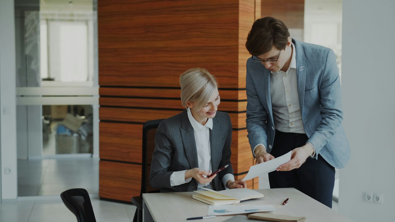Two professionals reviewing documents in an office