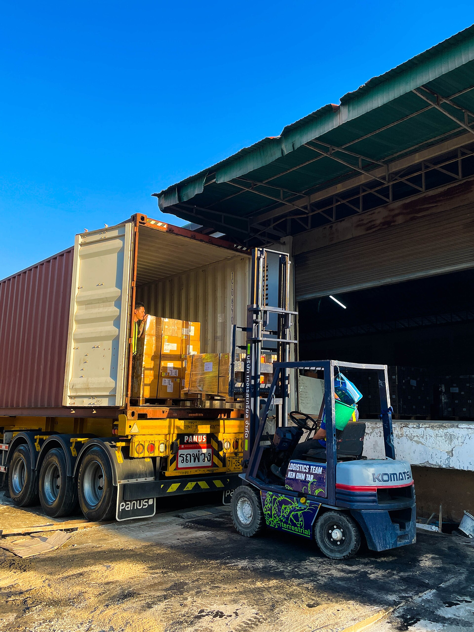 Forklift loading palletized cargo into a shipping container
